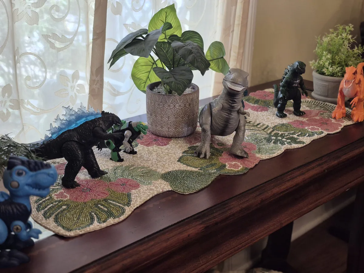 Dinosaur birthday decorations displayed with plants and greenery